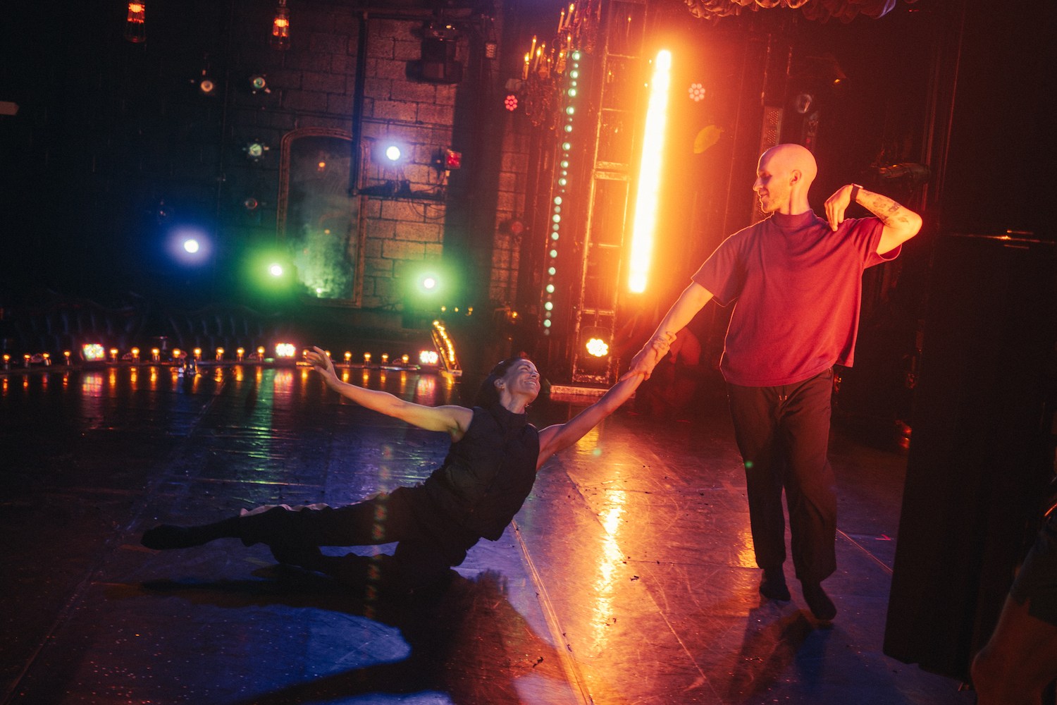 a woman and man practicing a dance member on stage