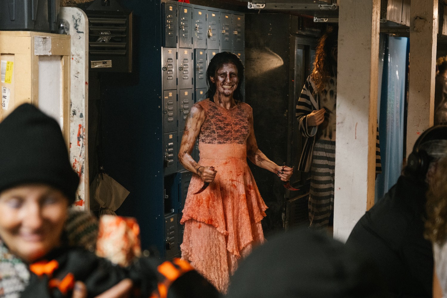 a woman in scary makeup wearing a lace dress and holding two bloody knives