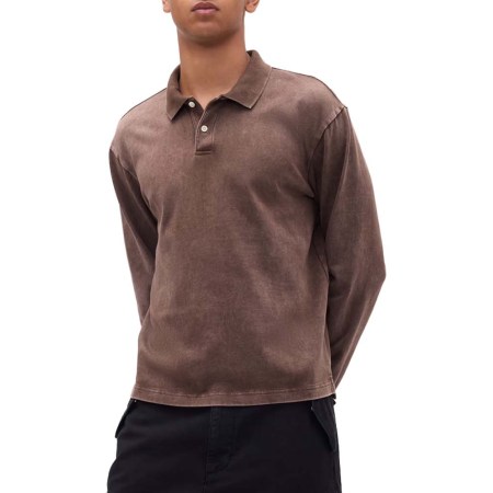 Man wearing a long-sleeved, faded brown polo shirt with two white buttons, paired with black pants.