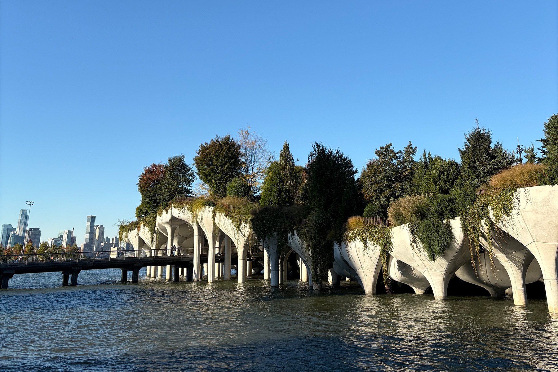 Little Island, a park on concrete pilings in the Hudson River, with a bridge to Manhattan.