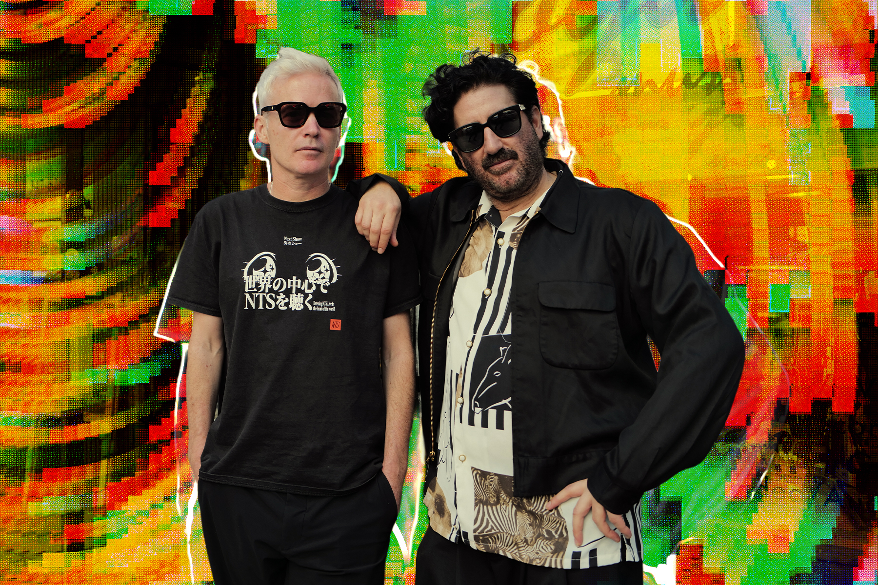 Two men in sunglasses, one with white hair and one with a beard, pose against a vibrant, glitchy background.