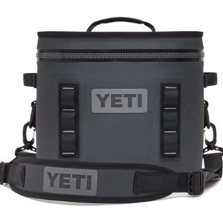 A dark gray Yeti Hopper Flip 12 soft cooler with a top handle and shoulder strap, on a white background.