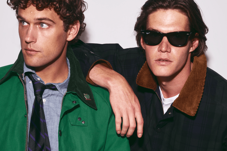 Two men in jackets with corduroy collars, one in green with a tie, the other in plaid with sunglasses.